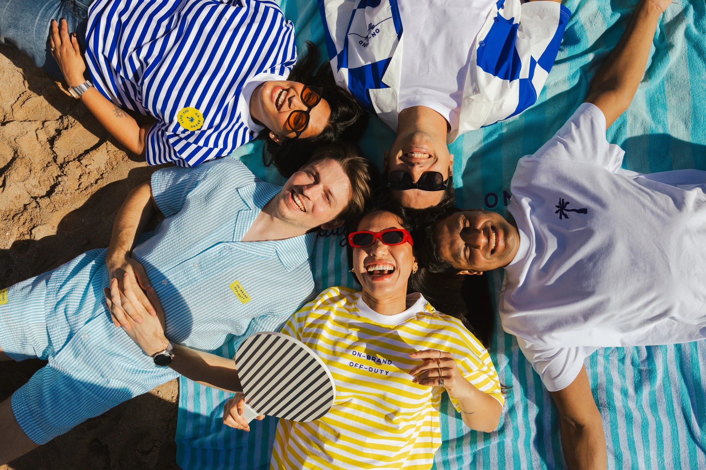 Guests gathered on a beach blanket at the Creative Cabana